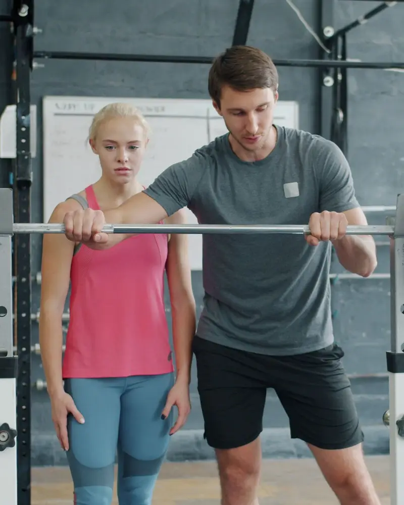 Coach setting a lifter's grip width on the barbell